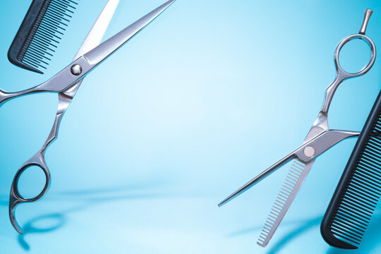 Flying hairdresser tools comb, scissors under trendy color background with copy space and soft light. Stylish Professional Barber Scissors, Hairdresser salon concept, Haircut accessories.