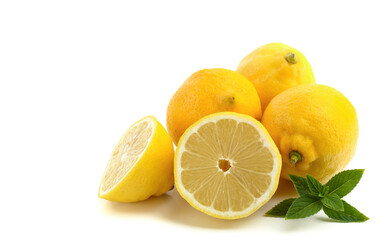 lemons whole and sliced, mint leaves, close-up on a white background, text space, horizontal view