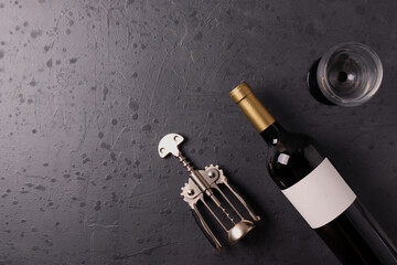 a bottle of red wine on the stone dark grey concrete grunge surface. minimalism style. top view. ...