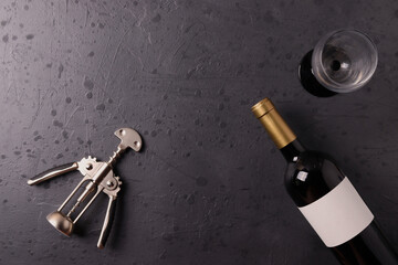 a bottle of red wine on the stone dark grey concrete grunge surface. minimalism style. top view.  copy space for text