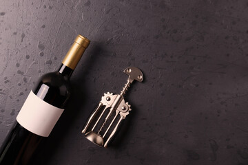 a bottle of red wine on the stone dark grey concrete grunge surface. minimalism style. top view.  copy space for text