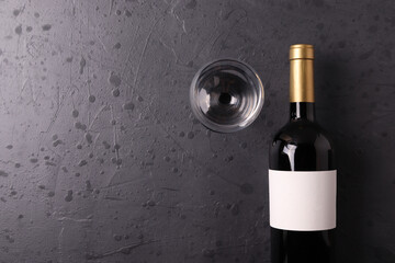 a bottle of red wine on the stone dark grey concrete grunge surface. minimalism style. top view. ...