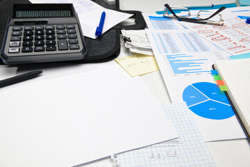Obraz premium business office desk closeup - financial reports, analysis and accounting, set of documents, tables and graphs, various items for bookkeeping, calculator