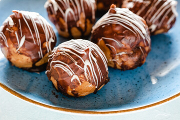 Mini puff cakes with vanilla pudding topped with chocolate