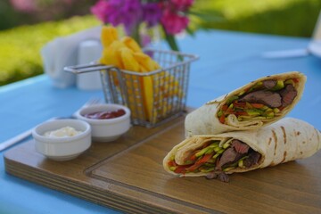 serving wrap with fries and sauces 