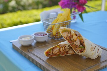 serving wrap with fries and sauces 