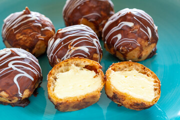 Mini puff cakes with vanilla pudding topped with chocolate