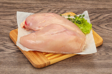 Raw chicken breast over board