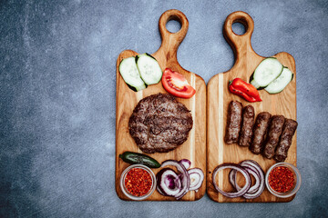 Kitchen board with vegetables and Turkish cevap and burger