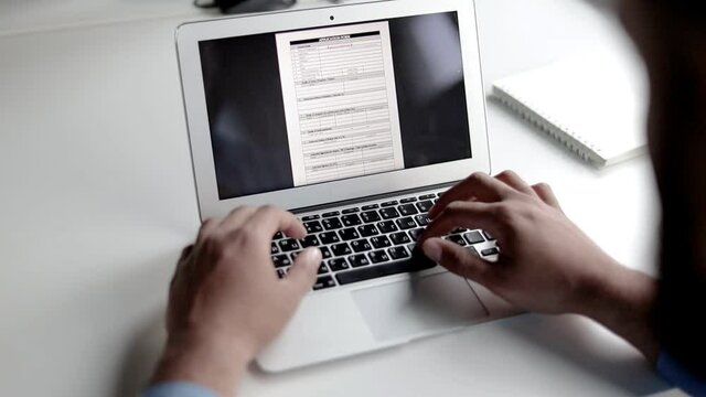 Hands Of Man Using Laptop, Typing, Filling Out Job Application Form On Display. Day, Closeup Shot. Communication Concept