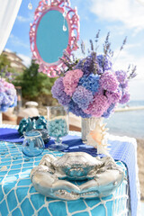 Decorated holiday table with crab, shells, flowers