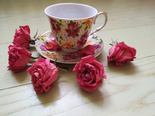 beautiful cup and saucer and dry pink roses