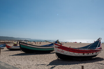 Naklejka na ściany i meble Two vintage fishing boats on the beach in Nazare Portugal