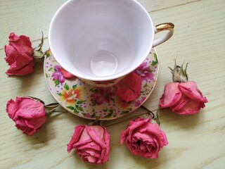 beautiful cup and saucer and dry pink roses