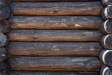 Old wooden log wall of the house.