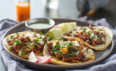 trio mexican carne asada tacos in corn tortilla on plate
