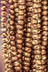 Close up shot of shiny golden beads - ideal for a glamorous background