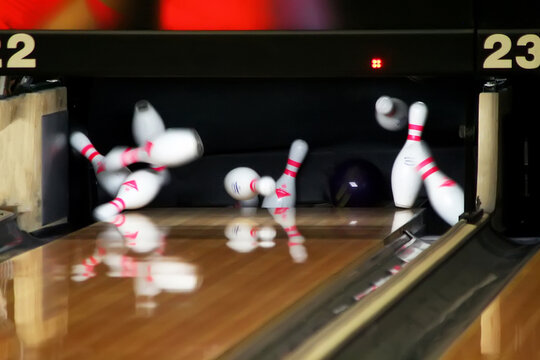 Bowling pins fly to the sides of a ball strike. spare
