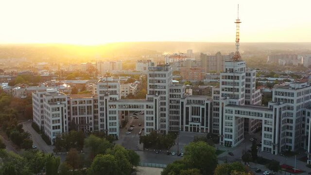 Flying over famous and historical building Gosprom of State Industry of Kharkov against background of beautiful sunset in summer. Ancient building in city center on Freedom Square, Ukraine.