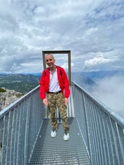 Ein Mann erholt sich auf dem Dachstein Gipfel auf einer Bank im Sommer