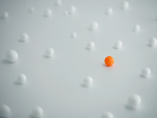 A scattering of white and red foam balls on a white background, short focus