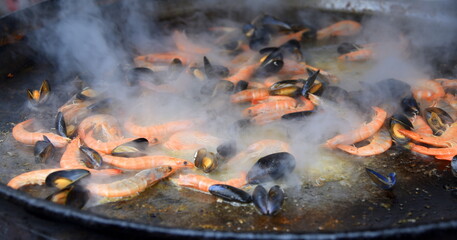 Gusseiserne Pfanne mit Garnelen und Muscheln im Dampf  © thauwald-pictures