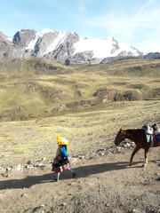 Peruvian Woman leading horse at Rainbow Mountain Peru and surrounding landscape 2019