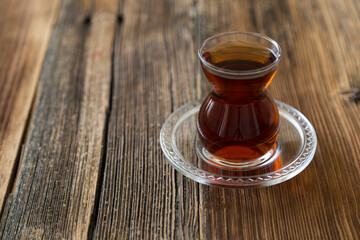 A glass of tea on the wooden background.