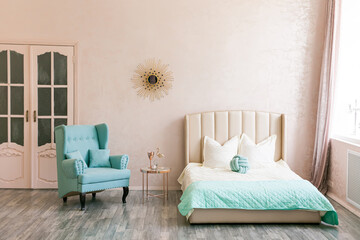 Real photo of a feminine bedroom interior with a comfy armchair, bed