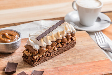 brownie cake with meringue on wooden table whit coffee