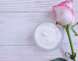  cosmetic cream rose flower on wooden background
