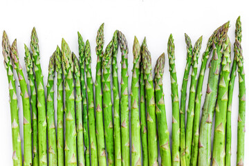 Bunch of fresh Asparagus on white background. Green raw sprouts of Asparagus Officinalis. Spring vegetables for healthy eating and lifestyle. Top View. Space for text.