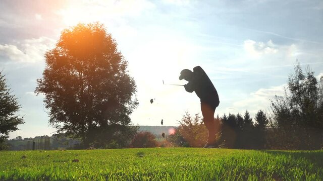 Golf Player plays golf on a beautiful summer morning. wide angle Lens flare Back lite ultra slow motion shot 