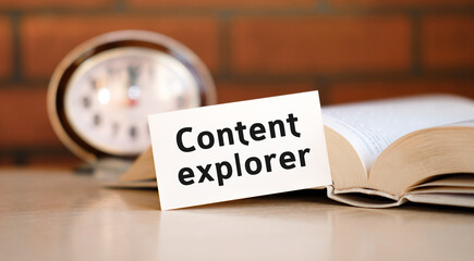 Content explorer concept text on a white background with a clock and an open book