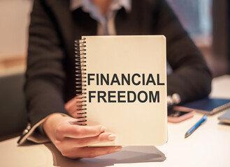 FINANCIAL FREEDOM business woman holding a notebook with the text. Concept