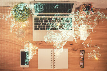 Social network hologram drawings over computer on the desktop background. Top view. Multi exposure. Concept of people connection.