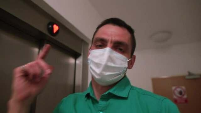 A masked video blogger makes a release into the elevator. Exchange of information over long distances in social distance.