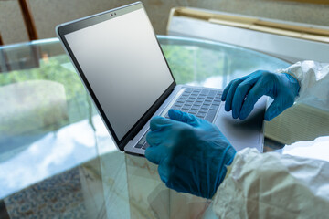 Physician with Blue gloves reviewing COVID-19 Data on a laptop computer