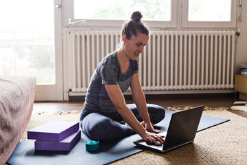 Yoga student doing online classes on laptop at home