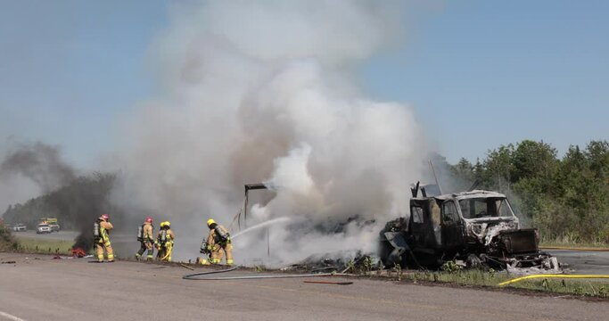Firefighter spray water on tractor trailer burning.