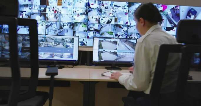 Security control room operator at work, Security System Operator Looking At Cctv Footage
