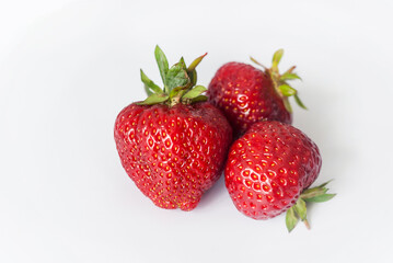 Eco or Bio Strawberry Isolated on White Background - Three Berries Composition Front View Close up Shot with Natural Light