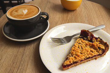 Cup of coffee and cake. Grated berry pie with a cup of cappuccino in a coffee shop. Selective focus. Breakfast concept