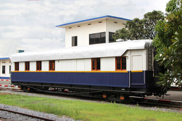 Fototapeta na wymiar White and blue passenger wooden railway wagon at station