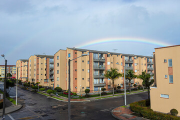 Fototapeta na wymiar Residential Unit neighborhood at sunny and rainy morning with rainbow and dark cloudy sky