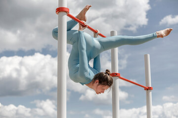 Fototapeta na wymiar acrobat girl in a blue suit on the street