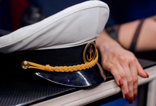 sailor's cap on the shelf of the woman's hand next to 