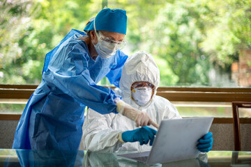 Physicians reviewing COVID-19 Data on a laptop computer