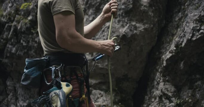 Climber protect rock climb partner pull brake by hand belay rope equipment safety gear hang outdoors lifestyle sport nature unrecognizable slow motion close up