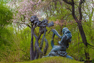 A female playing harp architecture in a park